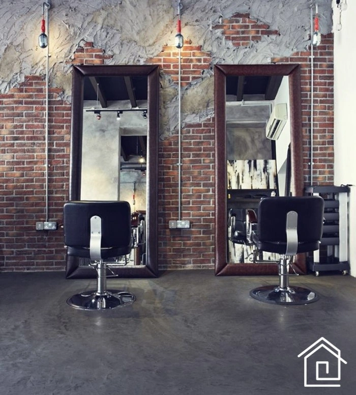 آرایشگاه مردانه صنعتی با دیوارهای آجری یا سیمانی، لوله‌های نمایان، چوب و فلزات تیره